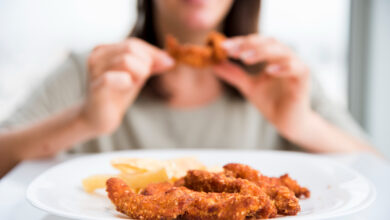 Fried chicken wings near eating woman